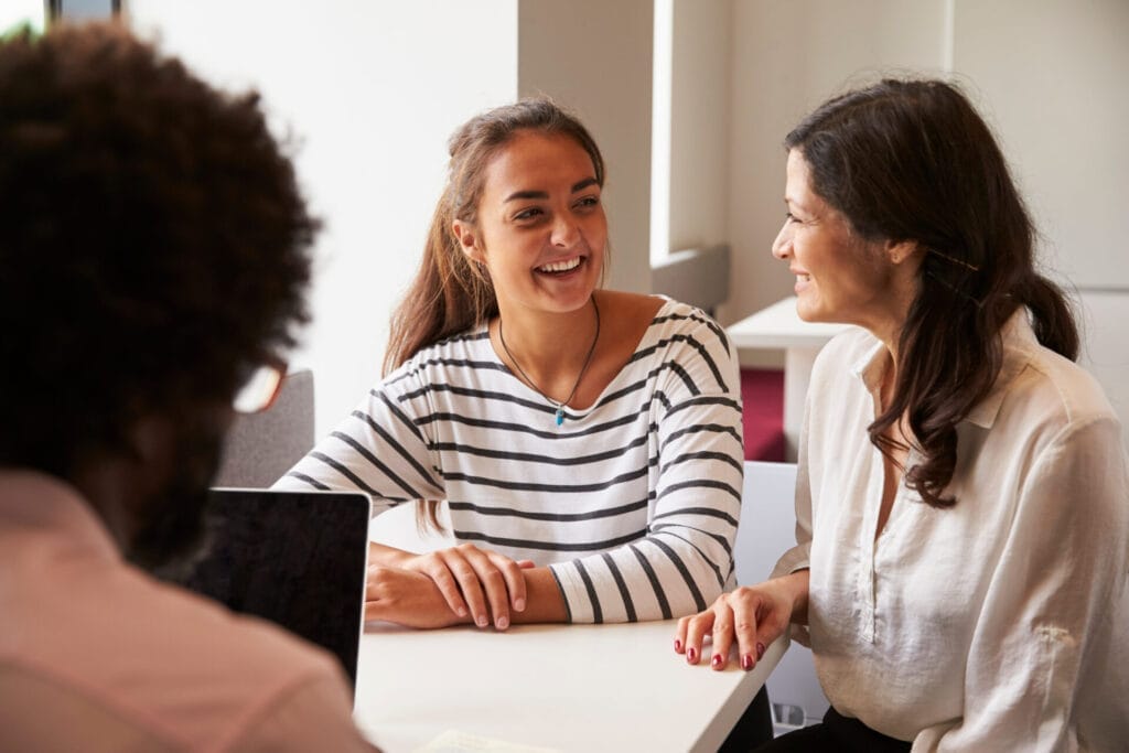 Mother and daughter meeting with male teacher at University