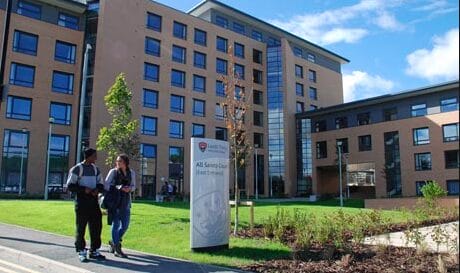 Leeds Trinity University exterior shot on a sunny day with students walking past
