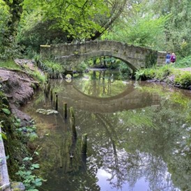 Meanwood area within Leeds, little bridge over a canal on a spring day with passers by.