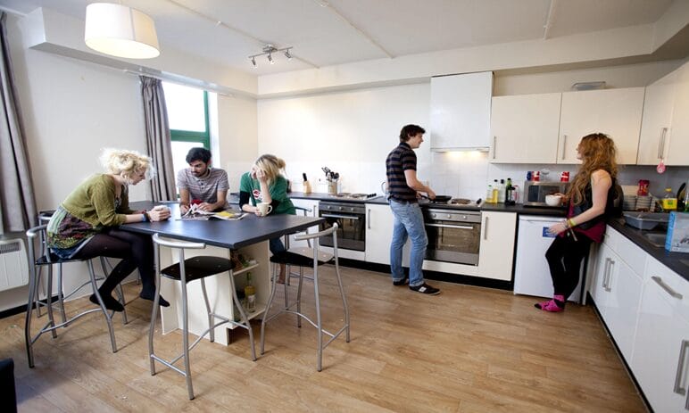 Students cooking and studying at a shared University Hall.