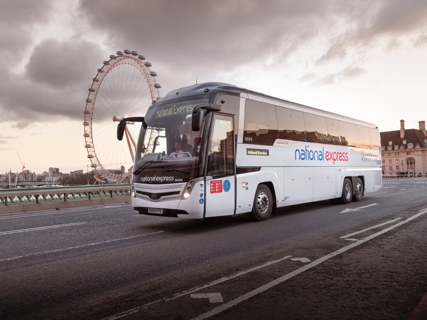 National Express coach crossing a bridge by The London Eye ride in London.