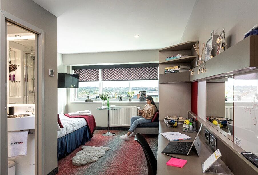 University student reading a book in her own en-suite room in Study Inn Nottingham.
