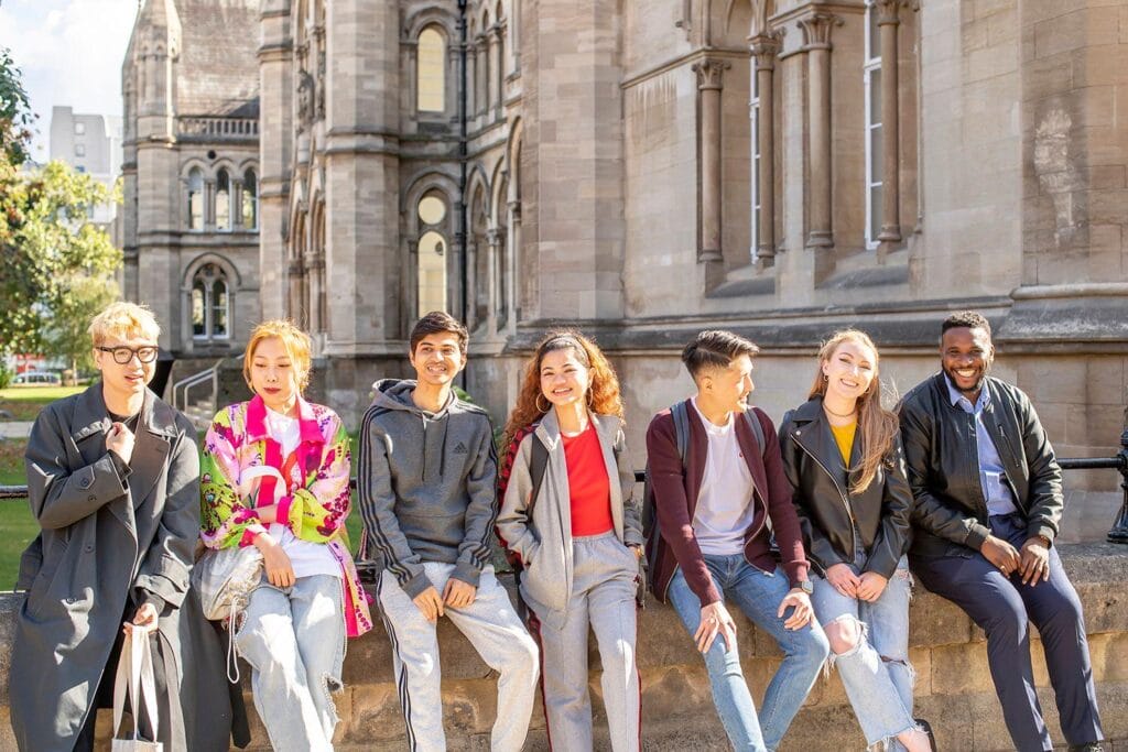 students sitting down together on a wall
