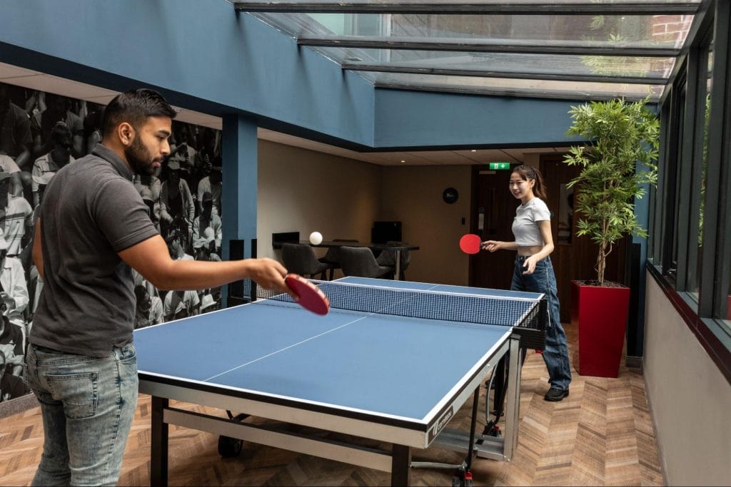 Students playing table tennis in a common area at the Study Inn accommodation in Exeter.