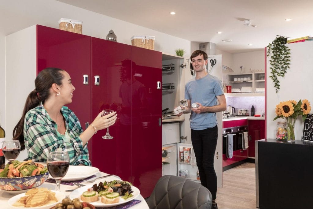 Two students in a modern kitchen at the Study Inn accommodation in Leeds, showcasing the communal living spaces.