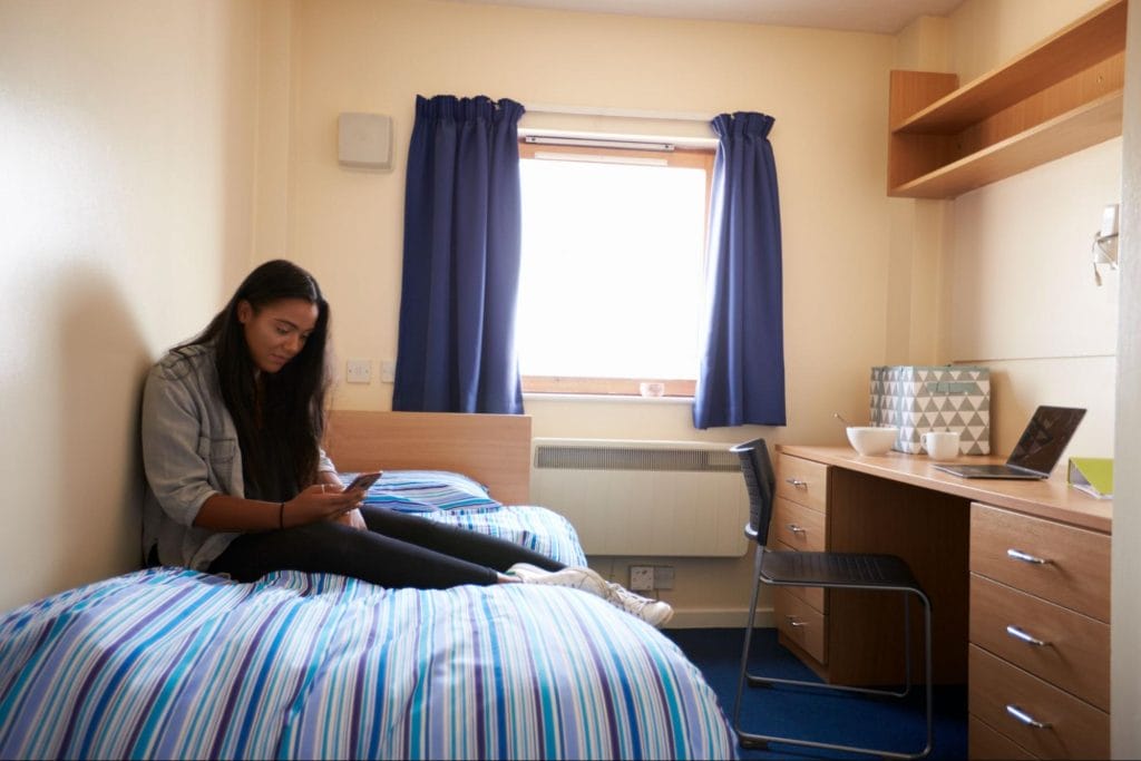 Student accommodation Leeds: A young student using her phone.