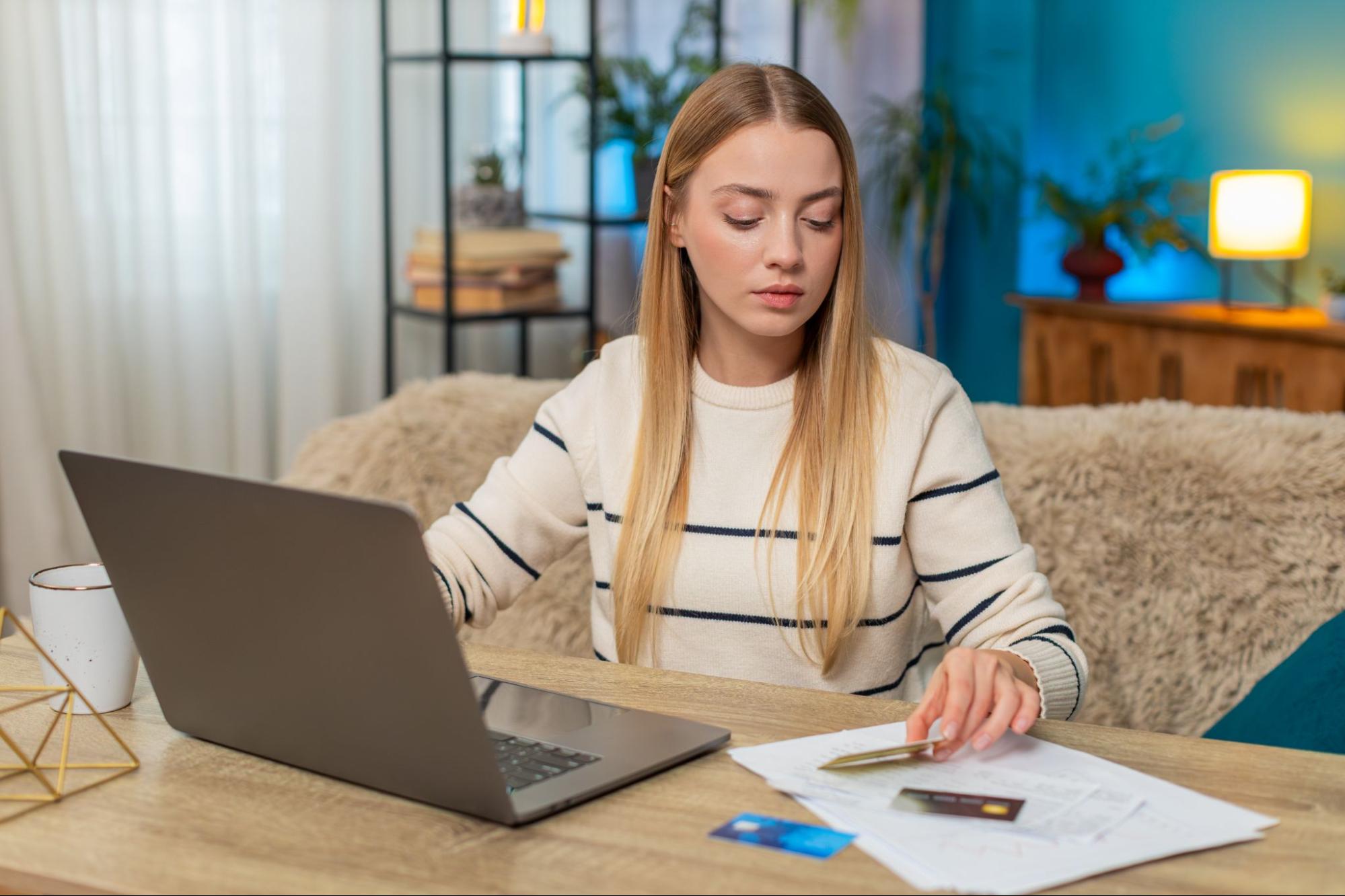 Student reviewing online bank statements and household expenses at student accommodation in Bristol, illustrating careful budgeting for student living costs