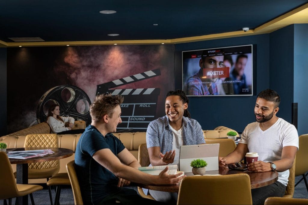 Students socialising and studying in the media lounge at Study Inn Student Accommodation in Exeter at Walnut Gardens