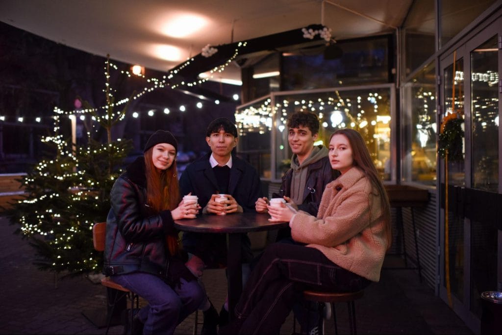 Students enjoying evening coffee under fairy lights in Bristol