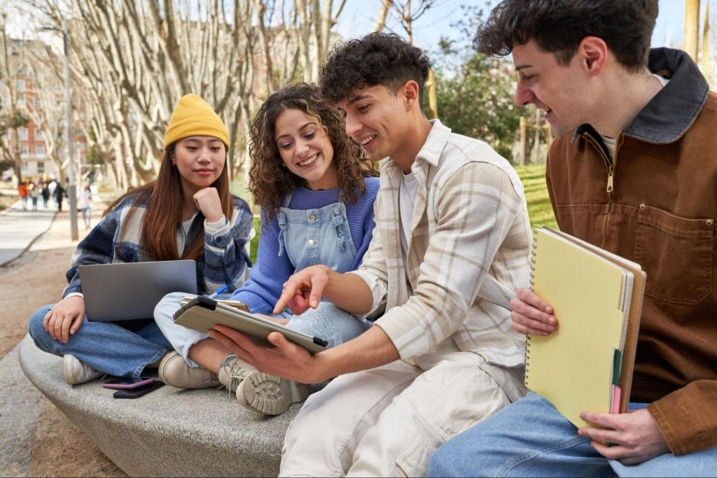 Group of university students studying together outdoors near luxury student housing in Nottingham