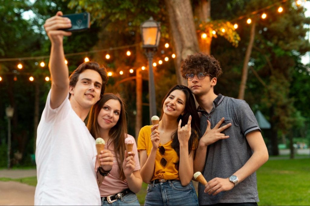 Group of students enjoying ice cream and taking selfies near luxury student accommodation in Nottingham