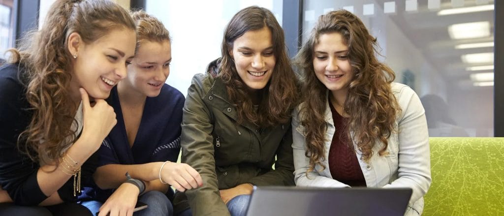 Students collaborating and studying on a laptop in a communal student accommodation study area in Exeter.